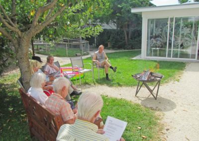 Menschen sitzen zusammen im Garten